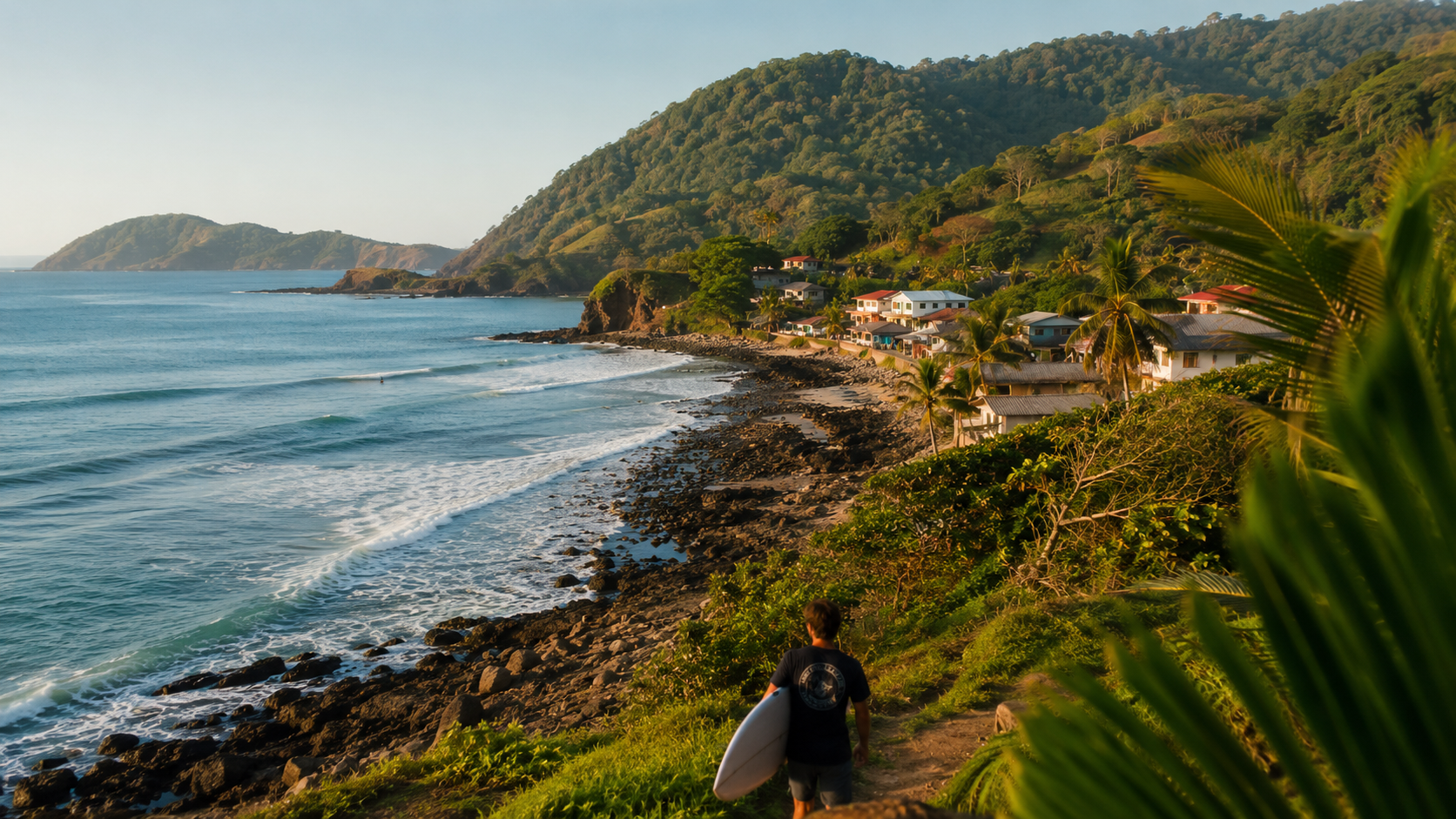 Surfer overlooking waves and a tropical Pacific coast village inspired by Santa Catalina